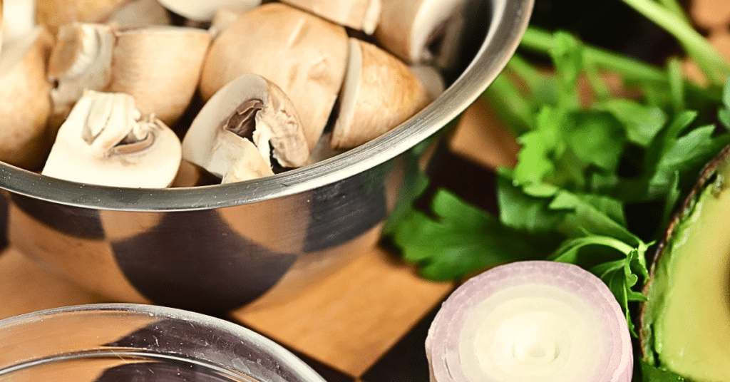 cut mushrooms in bowl with half a shallot and parsley leaves