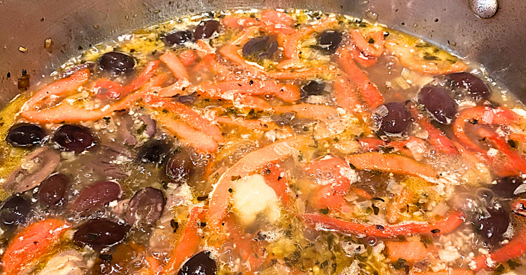 beurre Manie added to roasted peppers and kalamata olives in pan