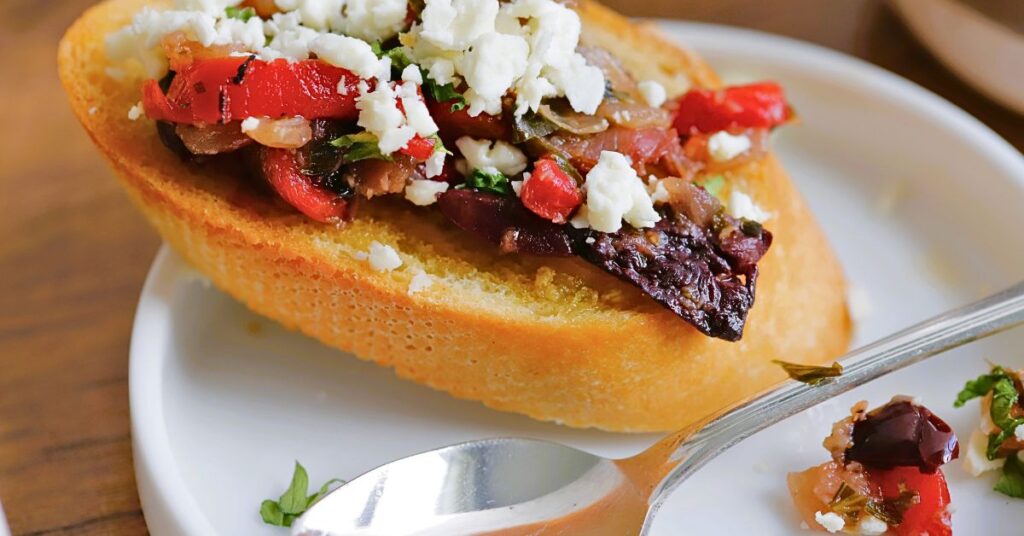 crostini with kalamata olives, roasted red pepper, prosciutto and feta cheese